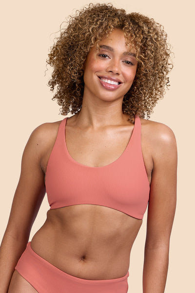 Female model wearing the Women's Blake Bikini Top in the Serrano Ribbed solid, standing in front of a yellow background, shown from the front view

|| Size S, Bust 32.5" 