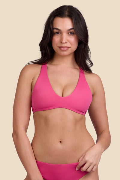 Female model wearing the Women's Doris Bikini Top in the Berry solid, standing in front of a yellow background shown from the front view

|| Size M, Bust 32"  
