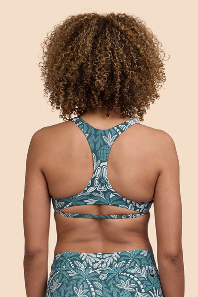 Female model wearing the Womens Doris Bikini Top in the Shorebreak print, standing in front of a yellow background shown from the back view

|| Size S, Bust 32.5"  