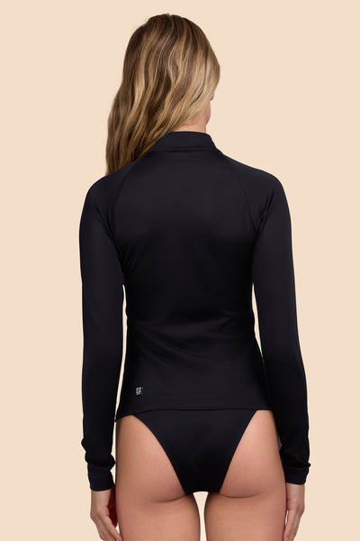 Female model wearing the Womens Erica Rashguard in the Black solid, standing in front of a yellow background shown from the back view

|| Size S, Bust 33"  