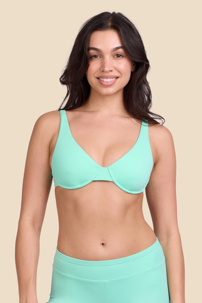 Female model wearing the Women's Hadley Bikini Top in the Mint Tulip solid, standing in front of a yellow background shown from the front view

|| Size M, Bust 32"  
