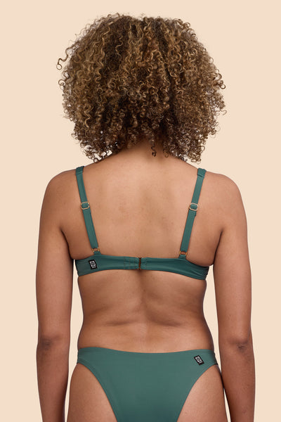 Female model wearing the Womens Hadley Bikini Top in the Zucchini solid, standing in front of a yellow background shown from the back view

|| Size S, Bust 32.5"  
