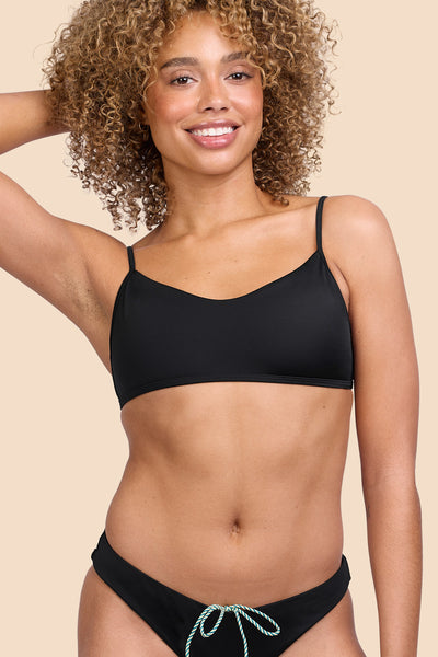 Female model wearing the Womens Hikari Bikini Top in the Black solid, standing in front of a yellow background shown from the front view

|| Size S, Bust 32.5"  