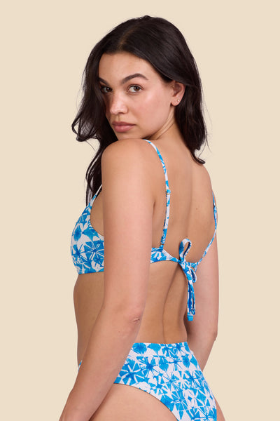 Female model wearing the Women's Hikari Bikini Top in the Bluefin print, standing in front of a yellow background shown from the side view

|| Size M, Bust 32"  
