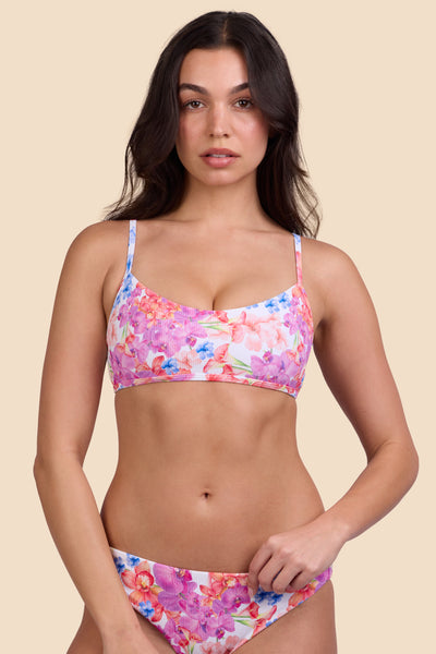 Female model wearing the Women's Hikari Bikini Top in the Orchids Ribbed print, standing in front of a yellow background shown from the front view

|| Size M, Bust 32"  
  