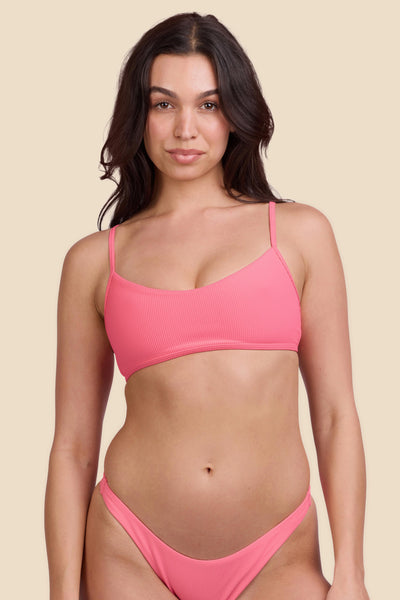 Female model wearing the Women's Hikari Bikini Top in the Tea Rose Ribbed solid, standing in front of a yellow background shown from the front view

|| Size M, Bust 32"  