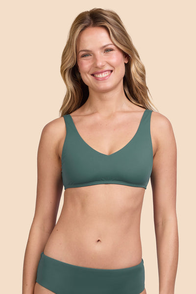 Female model wearing the Womens Kacey Bikini Top in the Zucchini solid, standing in front of a yellow background shown from the front view

|| Size S, Bust 33"  
