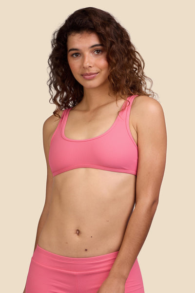 Female model wearing the Women's Larisa Bikini Top in the Tea Rose Ribbed solid, standing in front of a yellow background shown from the front view

|| Size S, Bust 35.5"  