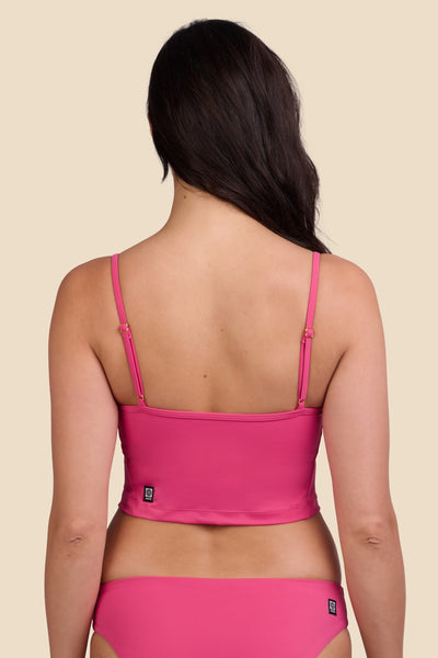 Female model wearing the Women's Luca Tankini Top in the Berry solid, standing in front of a yellow background shown from the back view

|| Size M, Bust 32"  
