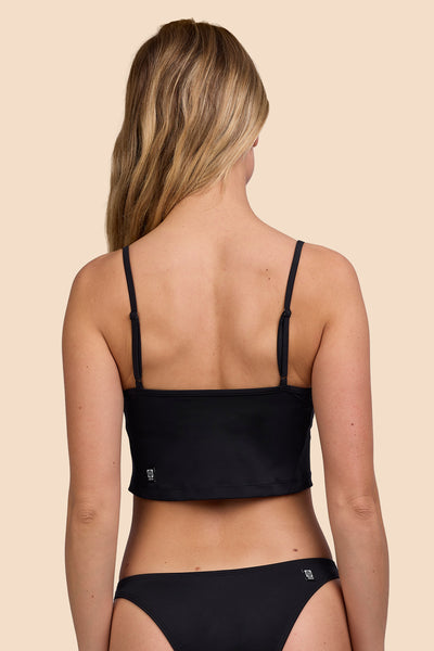 Female model wearing the Womens Luca Tankini Top in the Black solid, standing in front of a yellow background shown from the back view

|| Size S, Bust 33"  