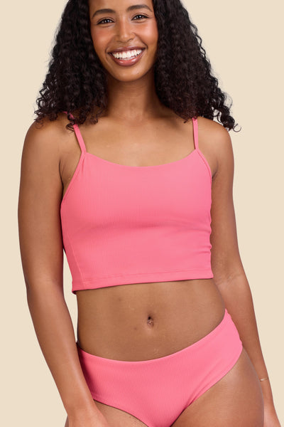 Female model wearing the Women's Luca Bikini Top in the Tea Rose Ribbed solid, standing in front of a yellow background shown from the front view

|| Size S, Bust 32"  