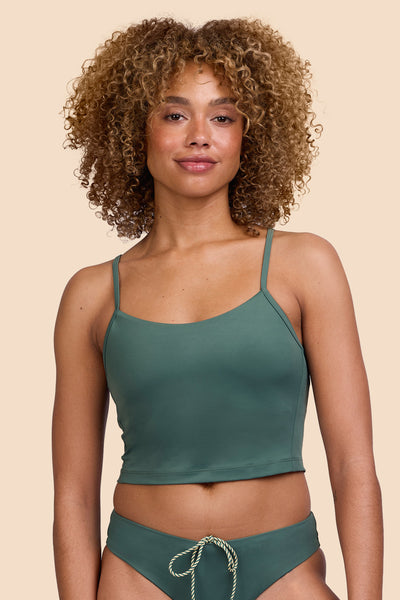 Female model wearing the Womens Luca Tankini Top in the Zucchini solid, standing in front of a yellow background shown from the front view

|| Size S, Bust 32.5"  
