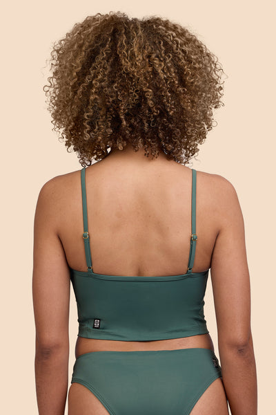 Female model wearing the Womens Luca Tankini Top in the Zucchini solid, standing in front of a yellow background shown from the back view

|| Size S, Bust 32.5"  