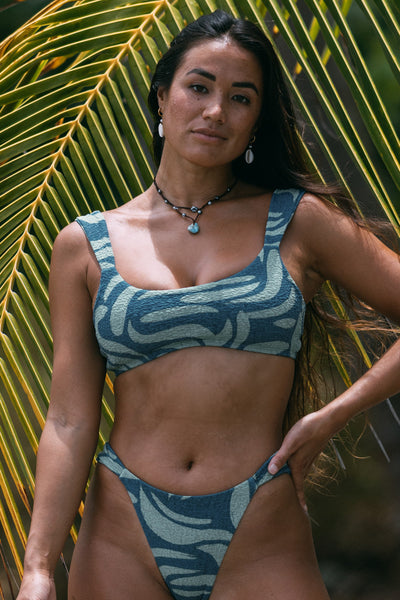 Female model wearing the Women's Lyra Bikini Top in the Sumatra print, standing in front of a green background shown from the front view

|| Size S, Bust 34"  