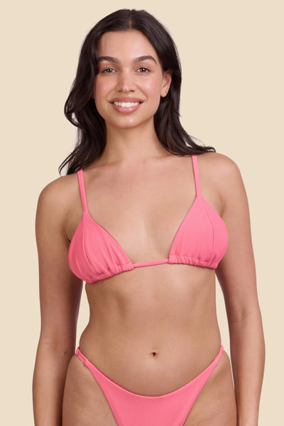 Female model wearing the Women's Margie Bikini Top in the Tea Rose Ribbed solid, standing in front of a yellow background shown from the front view

|| Size M, Bust 32"  