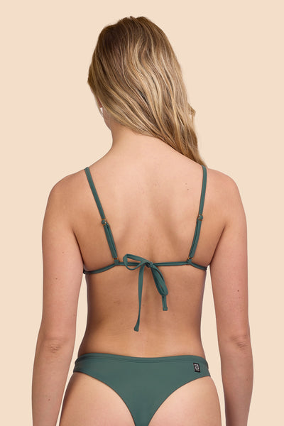 Female model wearing the Womens Margie Bikini Top in the Zucchini solid, standing in front of a yellow background shown from the back view

|| Size S, Bust 33"  
