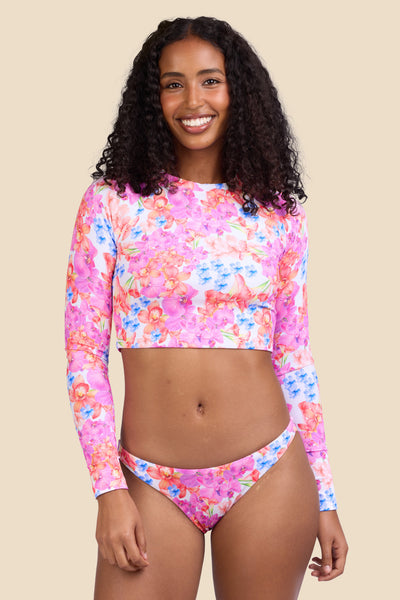Female model wearing the Women's Moana Rashguard in the Orchids ribbed print, standing in front of a yellow background shown from the front view

|| Size S, Bust 32" 