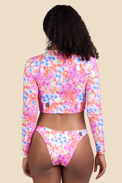 Female model wearing the Women's Moana Rashguard in the Orchids ribbed print, standing in front of a yellow background shown from the back view

|| Size S, Bust 32" 