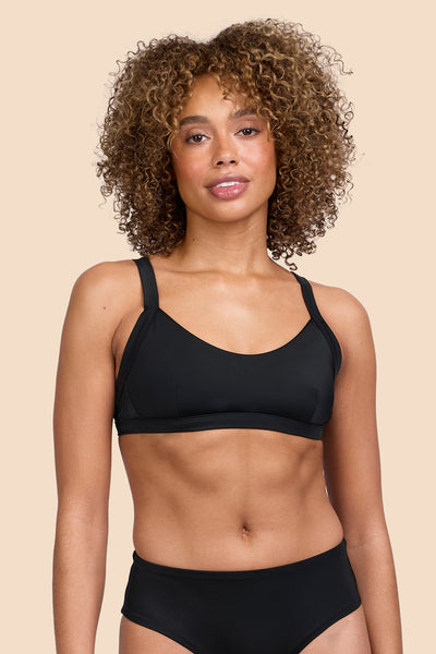 Female model wearing the Womens Nellie Bikini Top in the Black solid, standing in front of a yellow background shown from the front view

|| Size S, Bust 32.5"  