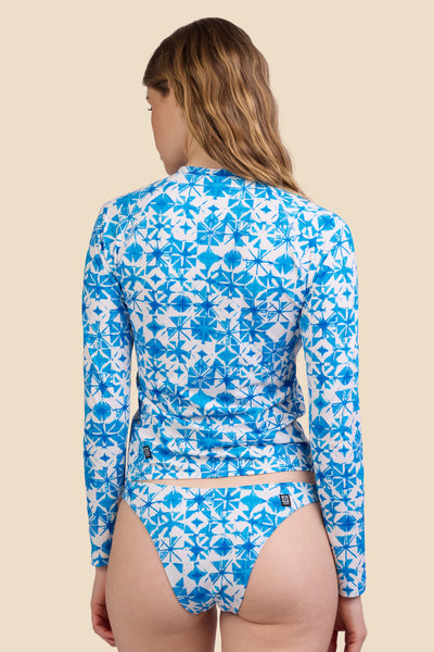 Female model wearing the Women's Noonan Rashie in the Bluefin print, standing in front of a yellow background shown from the back view

|| Size S, Bust 30.5"  
