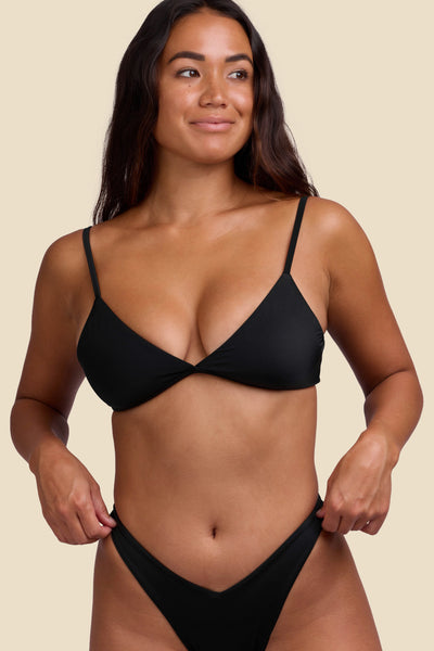 Female model wearing the Women's Vera Bikini Top in the Black solid, standing in front of a yellow background shown from the front view

|| Size S, Bust 34"  