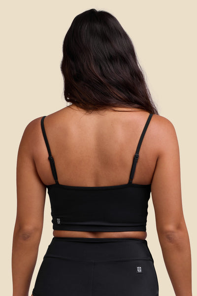 Female model wearing the Women's Wren Bikini Top in the Black solid, standing in front of a yellow background shown from the back view

|| Size S, Bust 34"  