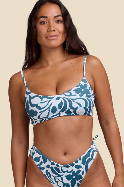 Female model wearing the Women's Zari Bikini Top in the Pua print, standing in front of a yellow background shown from the front view

|| Size S, Bust 34"  