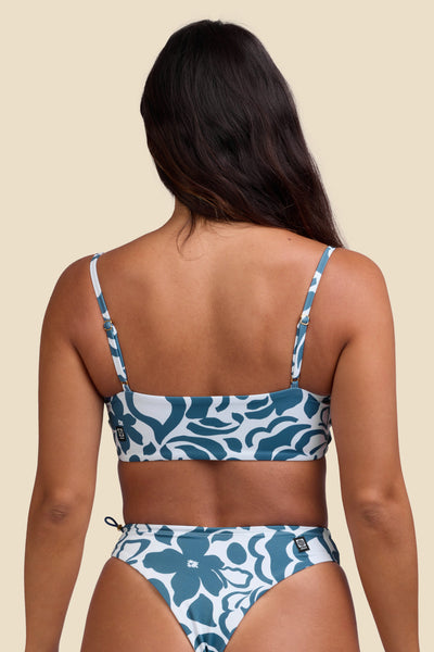 Female model wearing the Women's Zari Bikini Top in the Pua print, standing in front of a yellow background shown from the back view

|| Size S, Bust 34"  