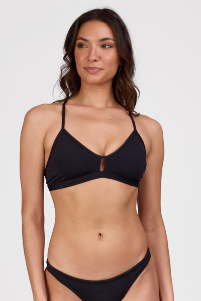Female model wearing the Women's Eviana Bikini Top in the Black solid , standing in front of a grey background shown from the front view

|| Size L, Bust 34"  
