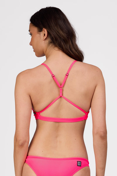 Female model wearing the Women's Eviana Bikini Top in the Hot Pink solid, standing in front of a grey background shown from the back view

|| Size L, Bust 34"  
