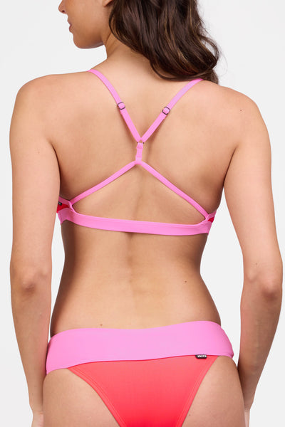 Female model wearing the Women's Eviana Bikini Top in the Neon Guava contrast, standing in front of a grey background shown from the back view

|| Size L, Bust 34"  
