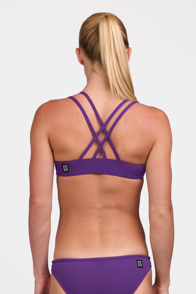 Female model wearing the Women's Fendrick Bikini Top in the Grape solid, standing in front of a grey background shown from the back view

|| Size S, Bust 33"