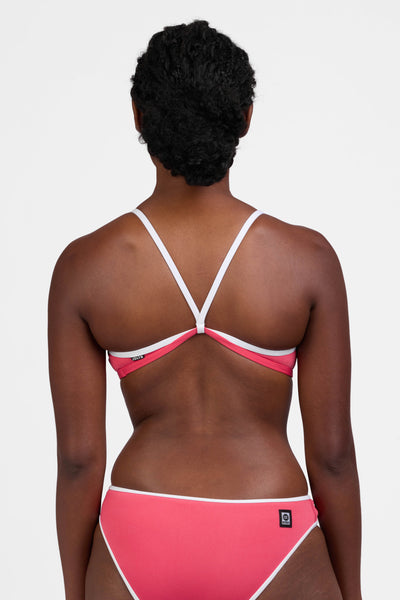 Male model wearing the Women's Jocelyn Bikini Top in the Guava Crush contrast, standing in front of a grey background, shown from the back view

|| Size M, Bust 34"  