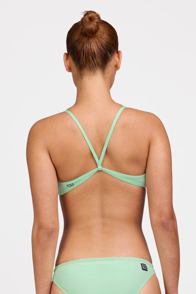 Female model wearing the Women's Jocelyn Bikini Top in the Mint solid, standing in front of a grey background shown from the back view

|| Size L, Bust 35"