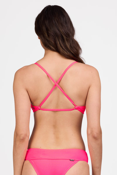 Female model wearing the Women's Noemi Bikini Top in the Hot Pink solid, standing in front of a grey background shown from the back view

|| Size L, Bust 34"  
