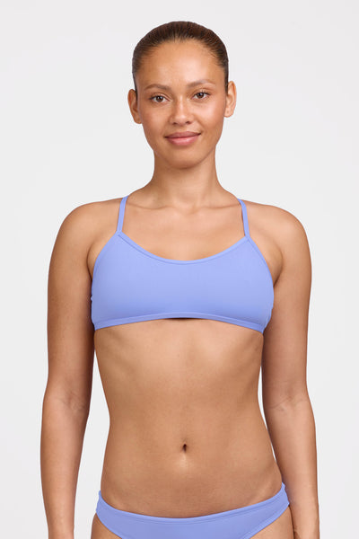Female model wearing the Women's Ryan Bikini Top in the Lavender solid, standing in front of a grey background shown from the front view

|| Size L, Bust 35"