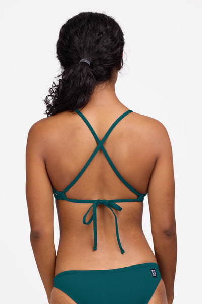 Female model wearing the Women's Ryan Bikini Top in the Peacock solid, standing in front of a grey background shown from the back view

|| Size S, Bust 32.5"