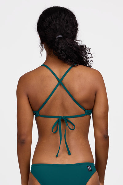 Female model wearing the Women's Tomcat Bikini Top in the Peacock solid, standing in front of a grey background shown from the back view

|| Size S, Bust 32.5"
