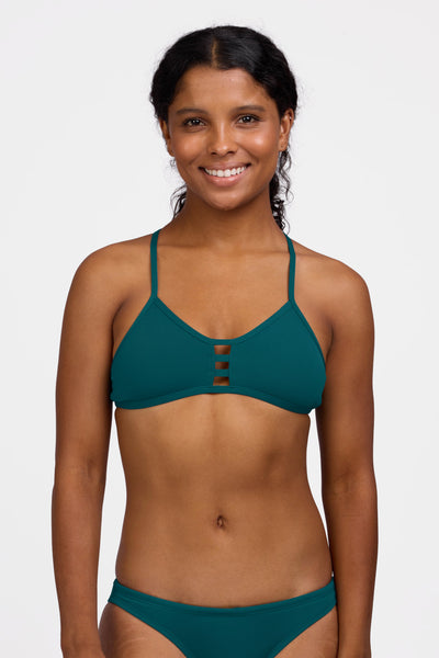Female model wearing the Women's Tomcat Bikini Top in the Peacock solid, standing in front of a grey background shown from the front view

|| Size S, Bust 32.5"
