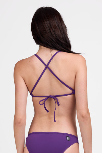 Female model wearing the Women's Triangle Bikini Top in the Grape solid, standing in front of a grey background shown from the back view

|| Size S, Bust 31"