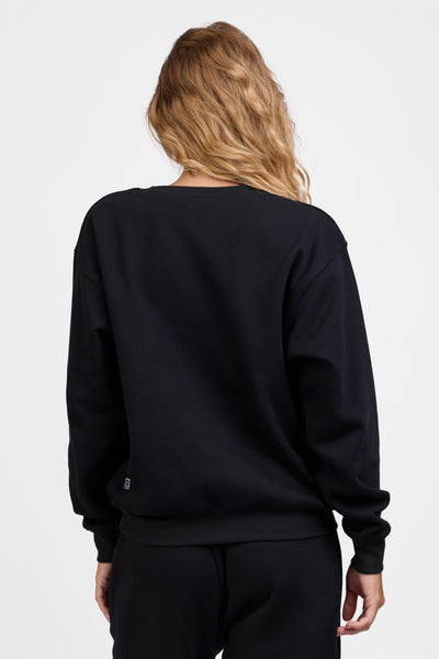 Female model wearing the Women's Ellison Crewneck in the Black solid, standing in front of a grey background, shown from the back view

|| Size S, Bust 31.5"  
