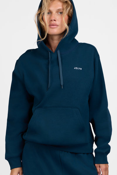 Female model wearing the Women's Lana Hoodie in the Indigo solid, standing in front of a grey background, shown from the front view

|| Size S, Bust 31.5"  