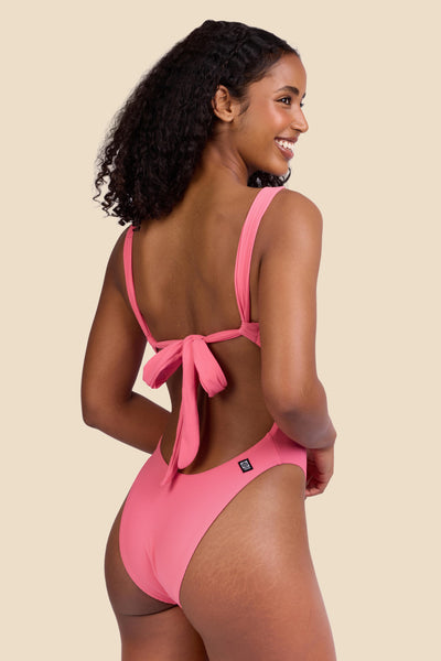 Female model wearing the Women's Jiro One Piece Swimsuit in the Tea Rose Ribbed solid, standing in front of a yellow background shown from the side view

|| Size S, Torso 59 1/2"  