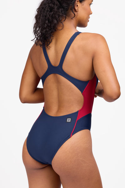 Female model wearing the Women's Amelie One Piece Swimsuit in the Navy Contrast, standing in front of a grey background shown from the side view

|| Size 30, Torso 59"