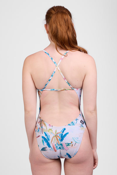 Female model wearing the Women’s Brandon One Piece Swimsuit in the Beach Day print, standing in front of a grey background, shown from back view. 