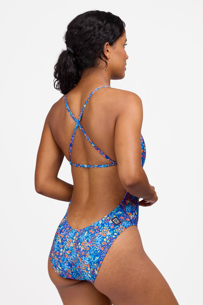 Female model wearing the Women's Brandon One Piece Swimsuit in the Calendula print, standing in front of a grey background shown from the side view 

|| Size 30, Torso 59"