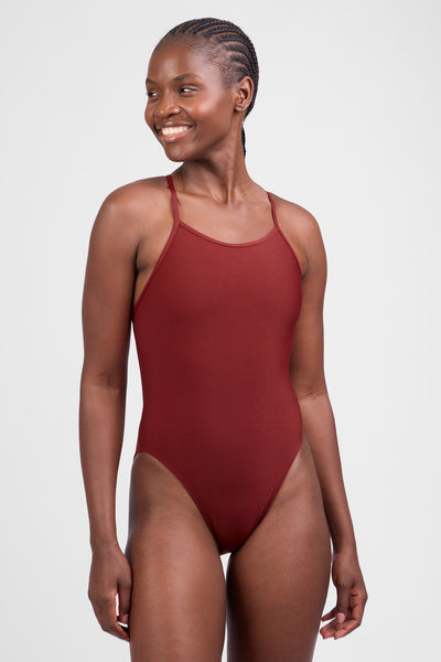 Female model wearing the Women’s Brandon One Piece in the Paprika solid, standing in front of a grey background, shown from front view. 
