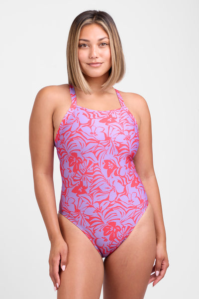Female model wearing the Women's Caroline One Piece Swimsuit in the Sundara print, standing in front of a grey background, shown from the front view. 