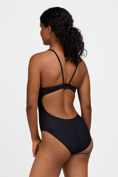 Female model wearing the Women's Devon One Piece Swimsuit in the Black solid, standing in front of a grey background shown from the side view

|| Size 30, Torso 59"  