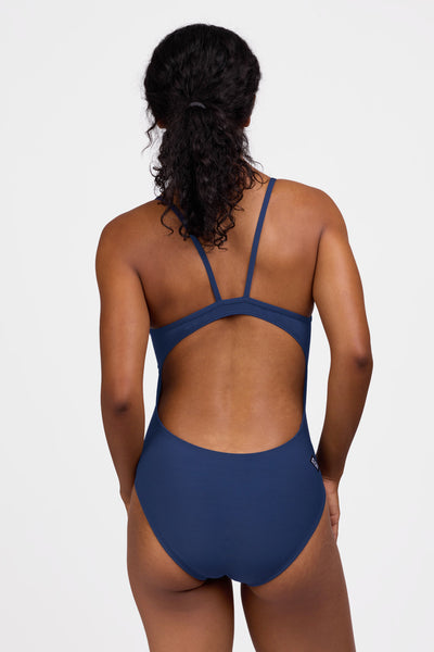 Female model wearing the Women's Devon One Piece Swimsuit in the Navy solid, standing in front of a grey background shown from the back view

|| Size 30, Torso 59"